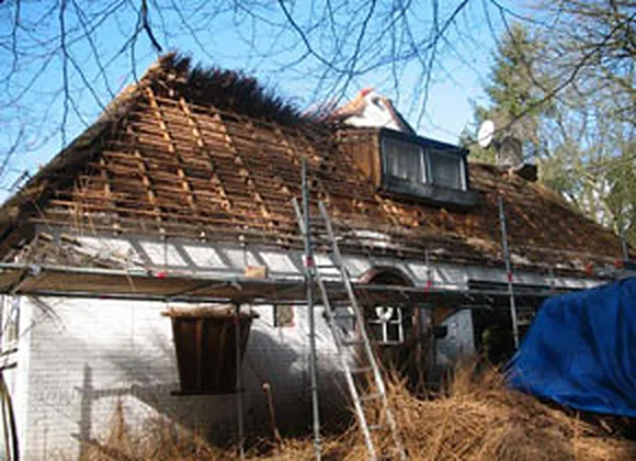 Woning in de steigers tijdens de renovatie van het rieten dak